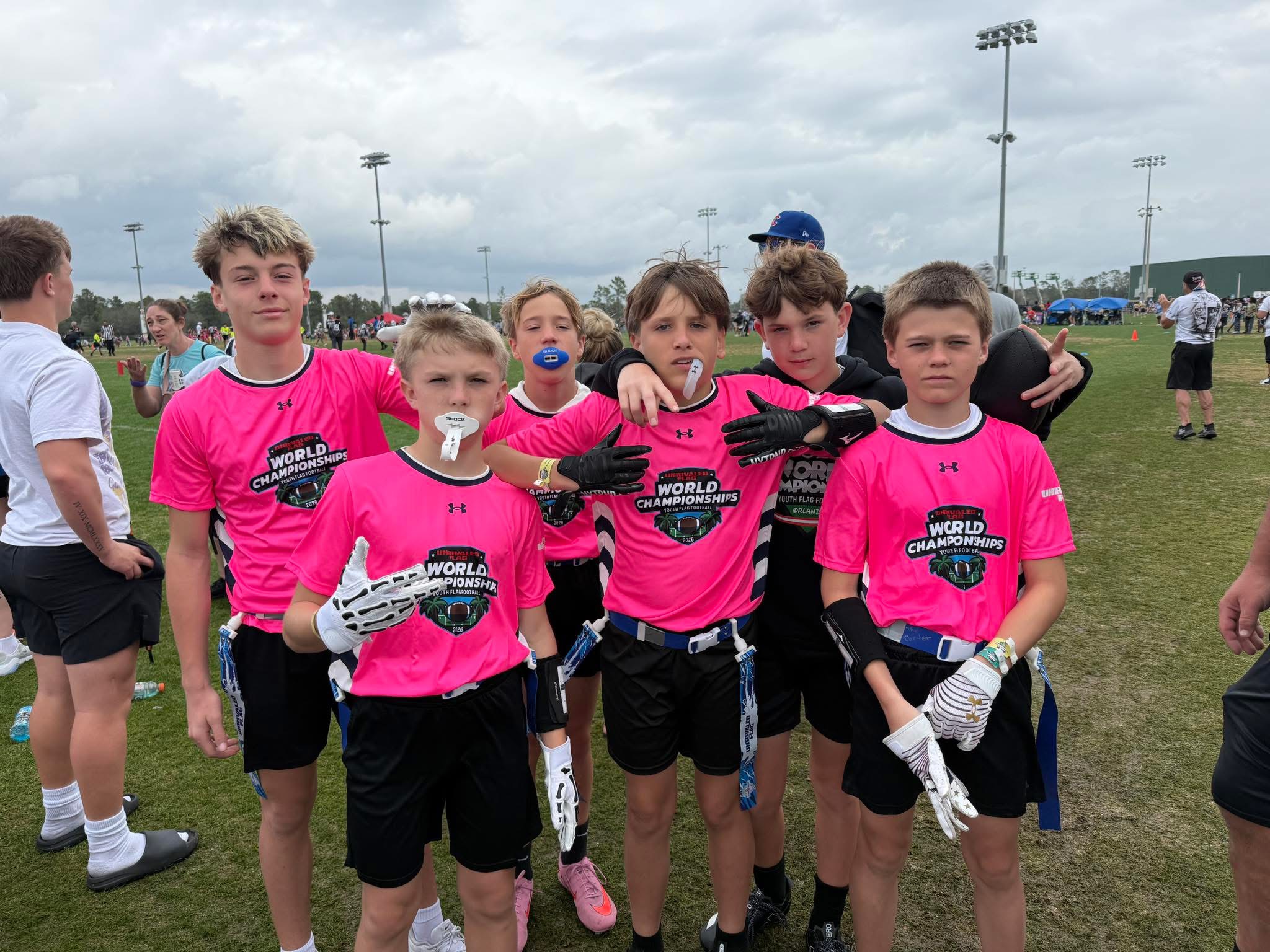 Detroit Legends youth players together on the field in pink tournament jerseys